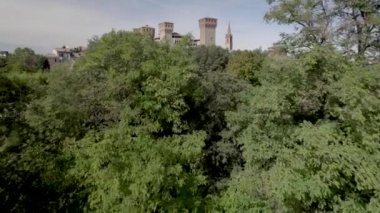 Mavi gökyüzü ve yeşil çevresiyle güneşli bir günde İtalya 'nın Emilia Romagna bölgesindeki Rocca Kalesi' ne doğru 4K ön hava aracı videosu. Yüksek kalite 4k görüntü