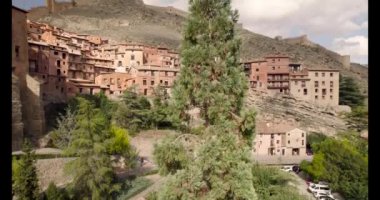 Kırmızı çatılar ve ortaçağ taş duvarları arasında Albarracin Village 'ın 4K insansız hava aracı videosu. Yüksek kalite 4K görüntü
