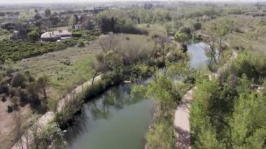 Anna Nehri 'nin alçak irtifa insansız hava aracı görüntüsü İspanya' nın Burriana kentindeki portakal ağaçları arasında geziniyor. Yüksek kalite 4K görüntü