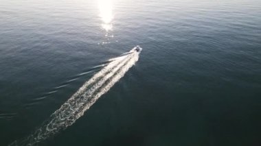 Okyanustaki açık denizde küçük bir yelkenli teknenin üzerinden yüksek açılı 4K video uçuşu. Yüksek kalite 4K görüntü