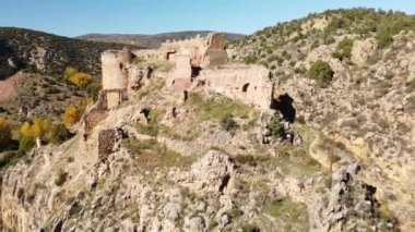 Drone fly-by over Santa Croce Castle ancient ruins in Albarracin on a sunny day with blue skies. High-quality 4k footage