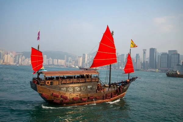 Kırmızı yelkenli Çin teknesi olan Hong Kong silueti. - Stok fotoğrafı. Yüksek kaliteli fotoğraf.