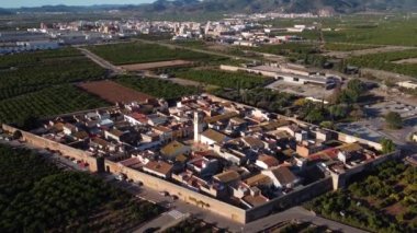 Drone 4K aerial view of footage of the Medieval village of Mascarell and its bell tower among stone walls in Spain. High-quality 4k footage