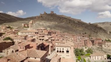Albarakin Ortaçağ köyü ve kırmızı çatılı evleri üzerinde geriye doğru alçak uçuş. Yüksek kalite 4K görüntü