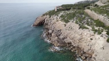 Akdeniz kıyısındaki Oropesa del Mar, İspanya 'daki ortaçağ deniz savunma kulesinin üzerinden alçak uçuş. Yüksek kalite 4K görüntü