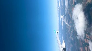 Almanya 'da yetiştirilmiş yeşil alanlar arasında iki nükleer santralle bulutların üzerinden inen bir uçağın 4K dikey uçuş görüntüsü. Yüksek kalite 4K görüntü