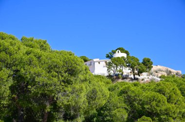 Güneşli bir günde Akdeniz Çam ağaçları arasındaki La Magdalena Hermitage 'in alçak açılı görüntüsü. Yüksek kaliteli fotoğraf.