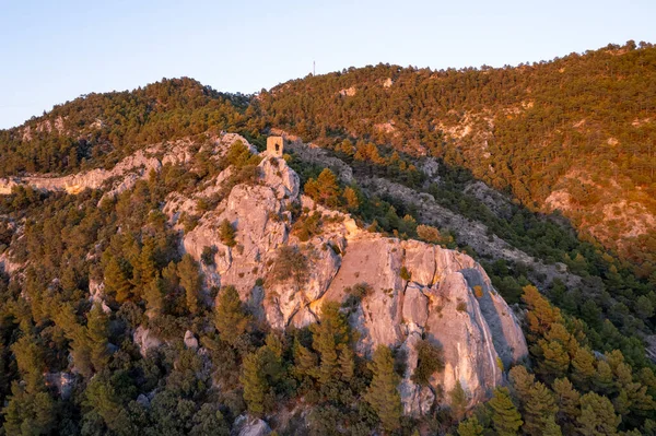 İspanya 'nın Sunset kentindeki dik bir kaya oluşumunun tepesinde küçük bir Akdeniz ortaçağ taş savunma kalesinin havadan görünüşü. Yüksek kaliteli fotoğraf.