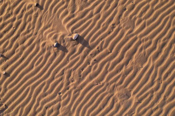 Üst görüntü, küçük kum tepeciklerinin yakın plan görüntüsü, küçük taşlar, rahatlatıcı arka plan. Yüksek kaliteli fotoğraf.