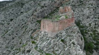Kayalık arazide duran ortaçağ tempo kalesi, yıpranmış taş duvarlar İspanya 'nın Castellon kentindeki Borriol manzarası boyunca panoramik manzaralı tarihi mimariyi gözler önüne seriyor. Yüksek kalite 4k görüntü
