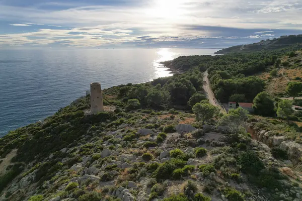 Drone top view of Torre de la Corda medieval defensive tower on a hill next to the Mediterranean seashore in Oropesa, Spain