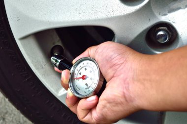 el araba lastik basınç ölçümü için basınç göstergesi tutarak