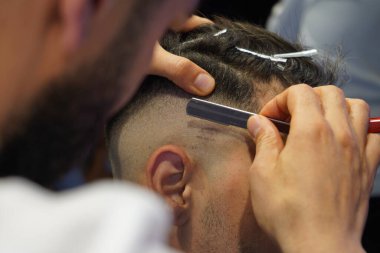 barber shop. man shaving his beard with scissors.