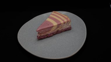 Koyu arkaplanda kremalı ve siyah jöleli lezzetli bir pasta..