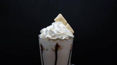 Krem şantili dondurma ve siyah arka planda çikolata.