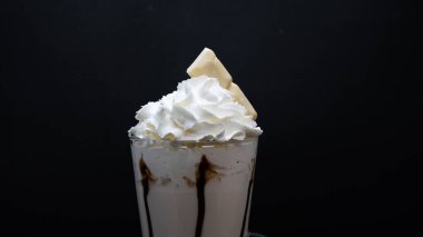 Siyah arka planda çırpılmış sütlü dondurma.