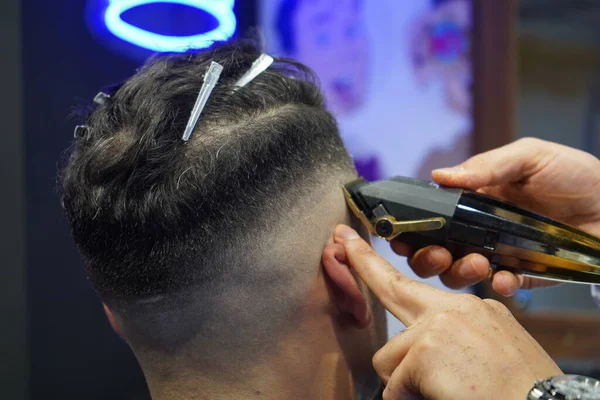man shaving hair with beard and comb in the salon