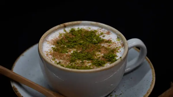 Bir bardak limonlu çay ve siyah arka planda yeşil bir yaprak.