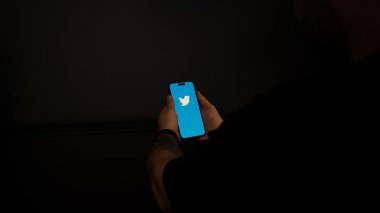 Siyah arkaplanı olan akıllı telefonu tutan.