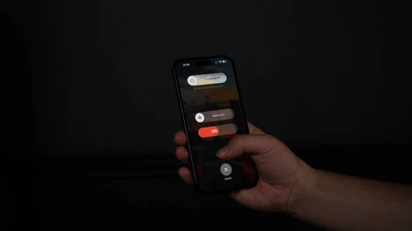 hand holding remote control on black background
