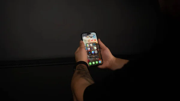 hand holding smartphone with black background
