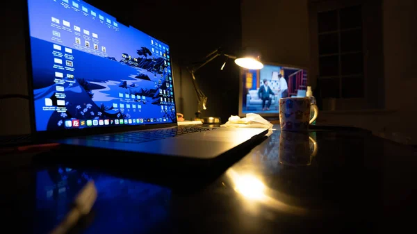 黒いテーブルの上にノートパソコンとオーバーヘッドランプがあります — ストック写真