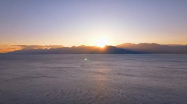 Kızıl güneş dağların arasından yükseliyor