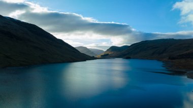 Harika göl ve gökyüzü manzarası. Dağların arasında mavi göl ve gökte bulutlar