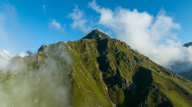 Dağ zirvesi. Orman dağının tepesinde bulutlar ve sis bulutu. Harika manzara fotoğrafı.