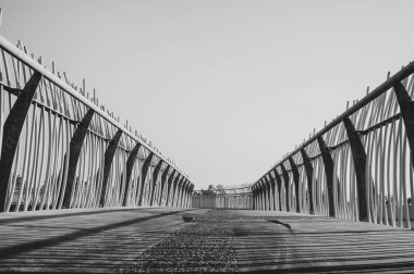 Yarrawonga yaya geçidinin alçak açılı siyah-beyaz fotoğrafı, güverte seviyesinde, metal korkuluk tasarımı ve inşaatının karmaşıklığını gösteriyor.