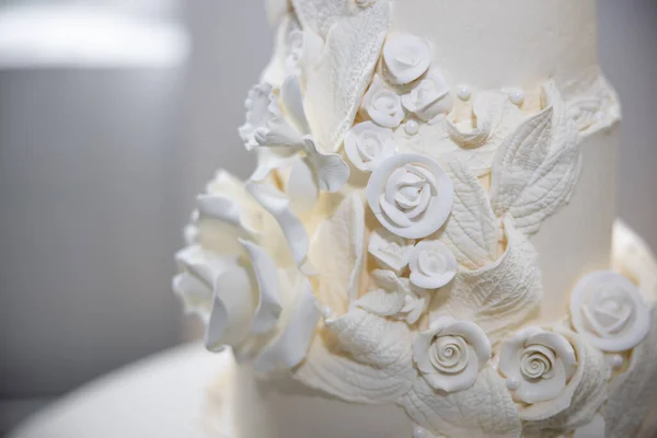 Masanın üzerinde kalp şeklinde süslenmiş beyaz düğün pastası. 