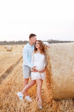 The girl dreamed with her lover about future parenthood. Blue shirt and shorts, white dress. The month of August is outside