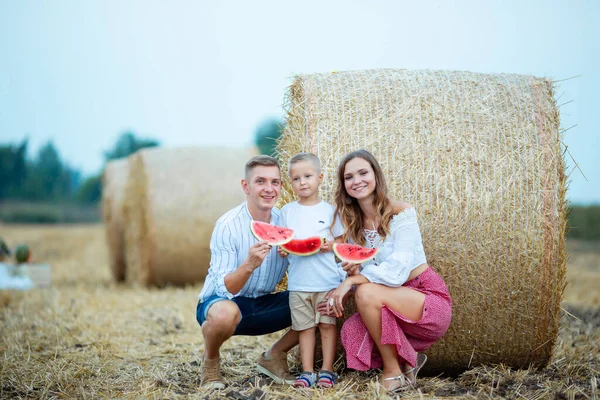 A family eats watermelon together