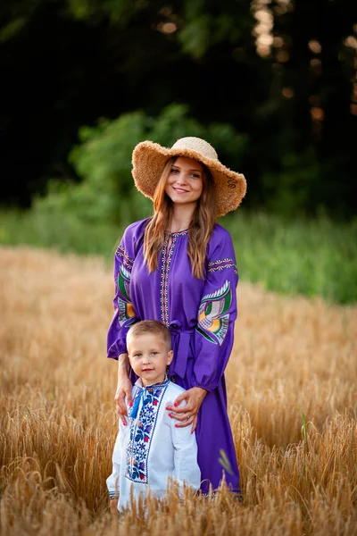 A mother with her son at sunset in a barley field in Ukraine