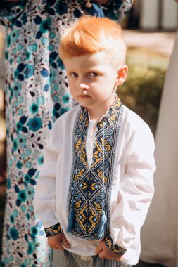 A red-haired boy in a Ukrainian white embroidered shirt. Symbolic clothes of victory and democracy