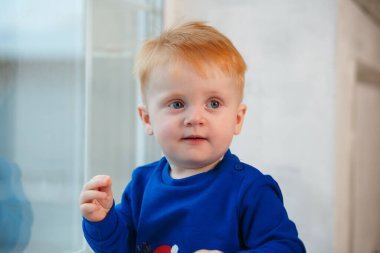 Portrait of a 2-year-old boy who still has no teeth and has red hair