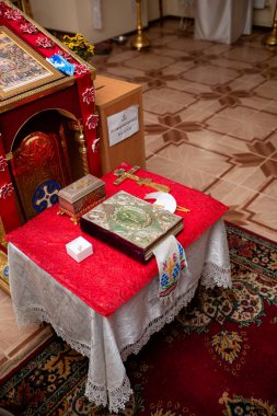 Vinnytsia, Ukraine. November 20, 2022: Bible in the Orthodox church. The sacrament of baptism and all the details. Icons on the table on the walls inside