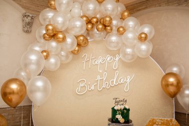 Happy birthday banner. Lots of bright balls and a delicious holiday cake