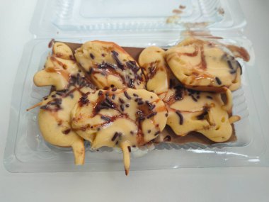 Yarı pişmiş Endonezya mini krepi (tutam kek veya kue cubit) üzerine çikolata serpiştirilmiş
