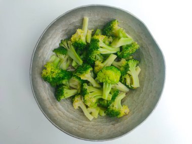 Beyaz arka planda demir kasede taze brokoli.