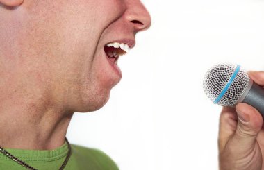 Adam mikrofona şarkı söyleyerek yaklaştı.