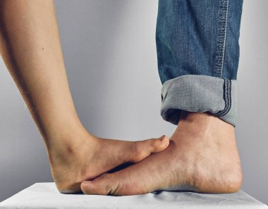 Baba ve kızı ayaklarıyla dokunuyor.