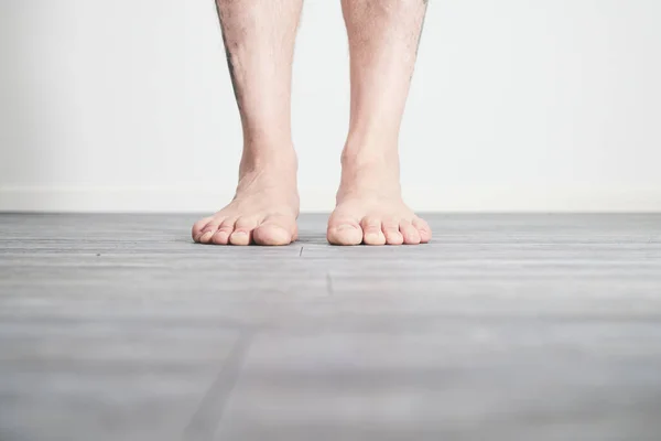 Male feet barefoot on floor