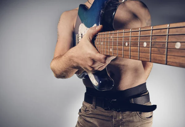 Guitar Player holding guitar towards camera