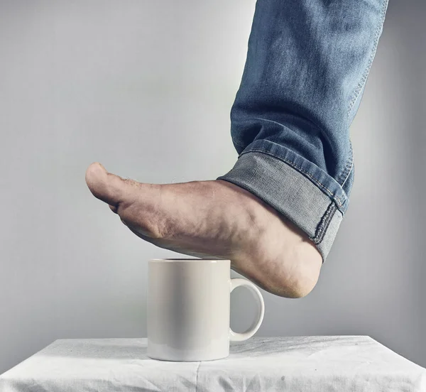 Männlicher Fuß Über Weißer Kaffeetasse Stockbild