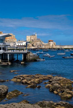 Tekneli bir liman ve arka planda bir bina.