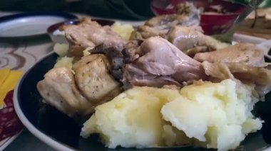 Bir tabak sıcak patates ve et. Şenlikli ev masası. Lezzetli yemekleri olan büyük bir şenlik masası. Aspic, kürk manto altında ringa balığı ve sosisli sandviç, arka plan. Sıcak patates ve et.. 
