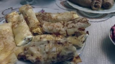 Peynirli ve kuru üzümlü kızarmış gözleme. Yakın plan. Kutlama masasındaki tabakta ev yapımı krepler. Peynirli ve kuru üzümlü kızarmış gözleme. Yakın plan. Yüksek kalite 4k görüntü