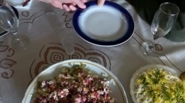 El, Noel yemeğini tabağa koyar. Somon salatası. Noel yemeğinde çeşitli yemekler, salatalar, et kesimleri, peynir, soğuk yemekler. El, Noel yemeğini tabağa koyar. Somon salatası Yüksek kalite 4K görüntü