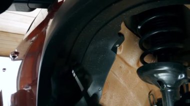 Benzin istasyonunda, bir çalışan tekerlek kemerinin plastik çamurluklarını tamir eden vidaları söküyor. Kolaylık olsun diye, amortisörün yanındaki gün ışığı lambasını tamir etti. Yüksek kalite 4k görüntü